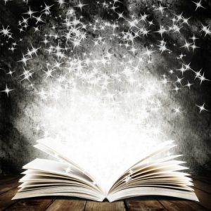 34031289 - old open book with magic light and falling stars on wood planks and dark abstract background