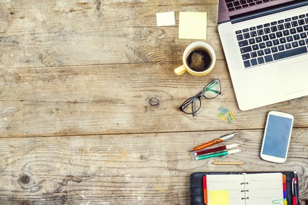 35800895 - mix of office supplies and gadgets on a wooden table background. view from above.